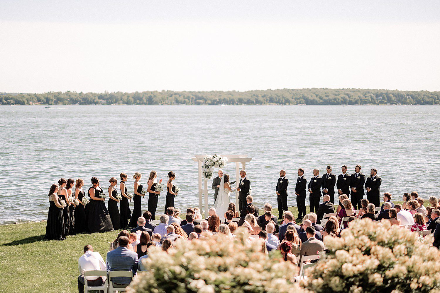 Jenna and Josh's bridal party lined up lakeside during their Heidel House wedding ceremony