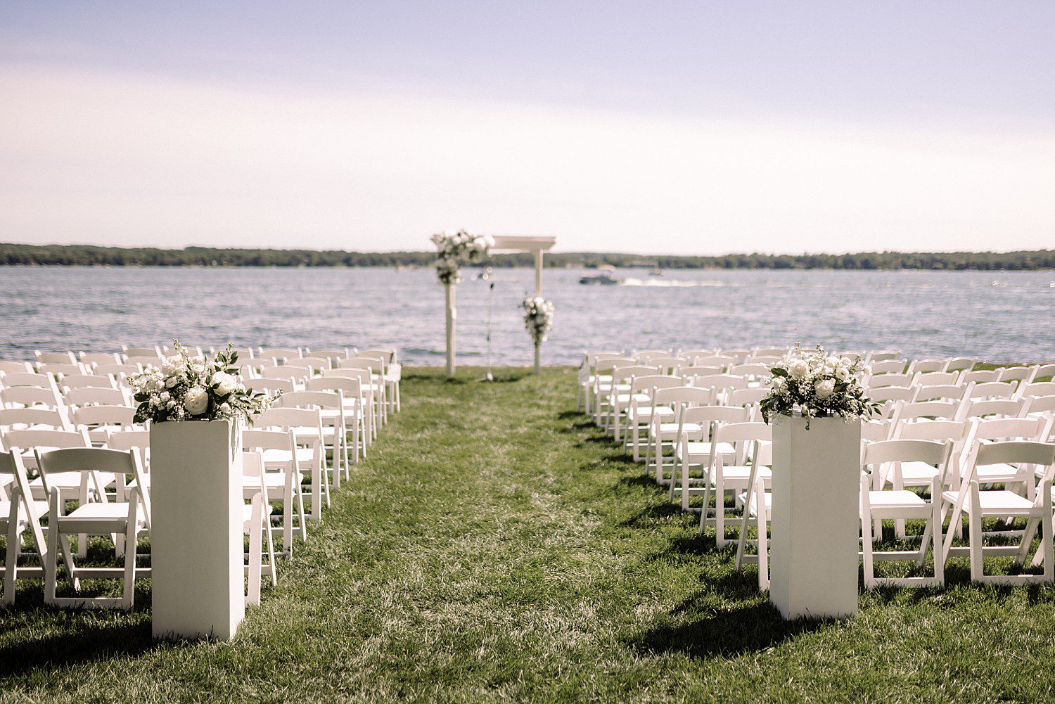 Jenna smiling at the camera with Josh by the water at their Heidel House lakeside wedding