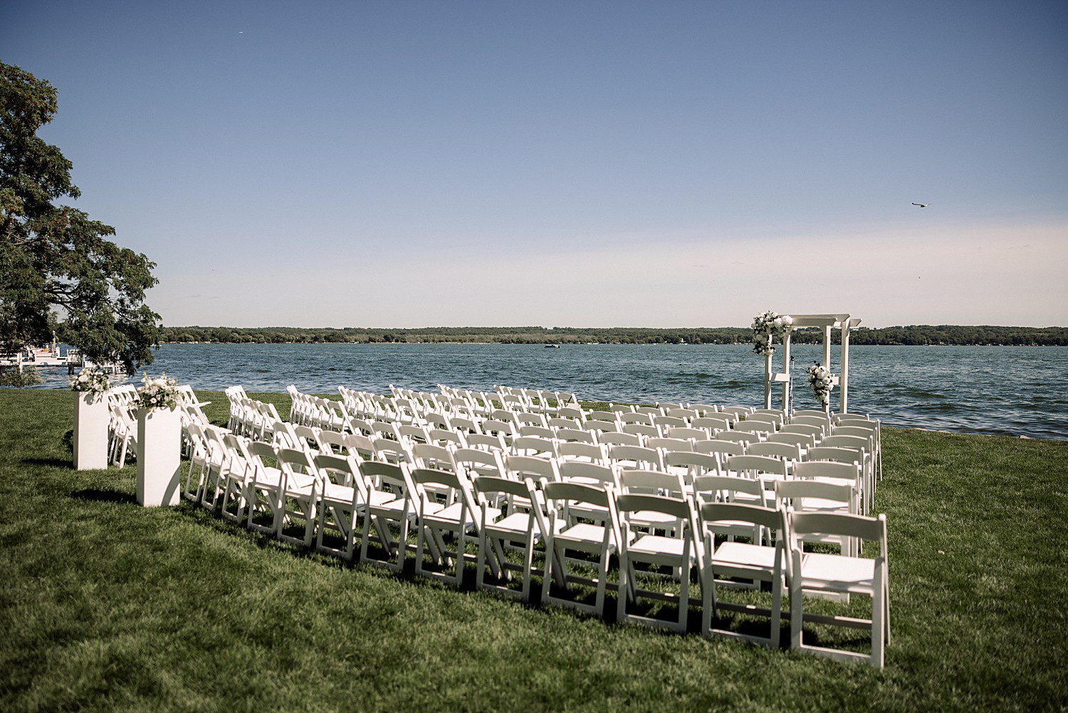Jenna laughing as she and Josh walk along the shoreline at their Heidel House wedding
