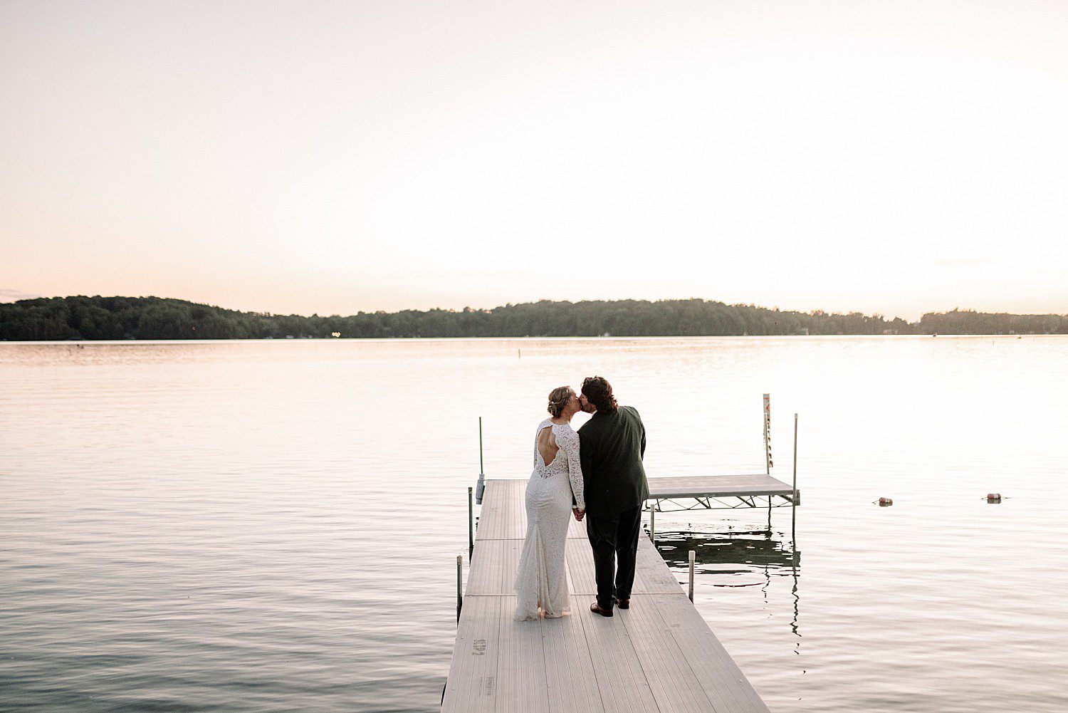 Kathryn and Logan kissing at the end of the dock over Elkhart Lake at The Osthoff Resort in Elkhart Lake, Wisconsin