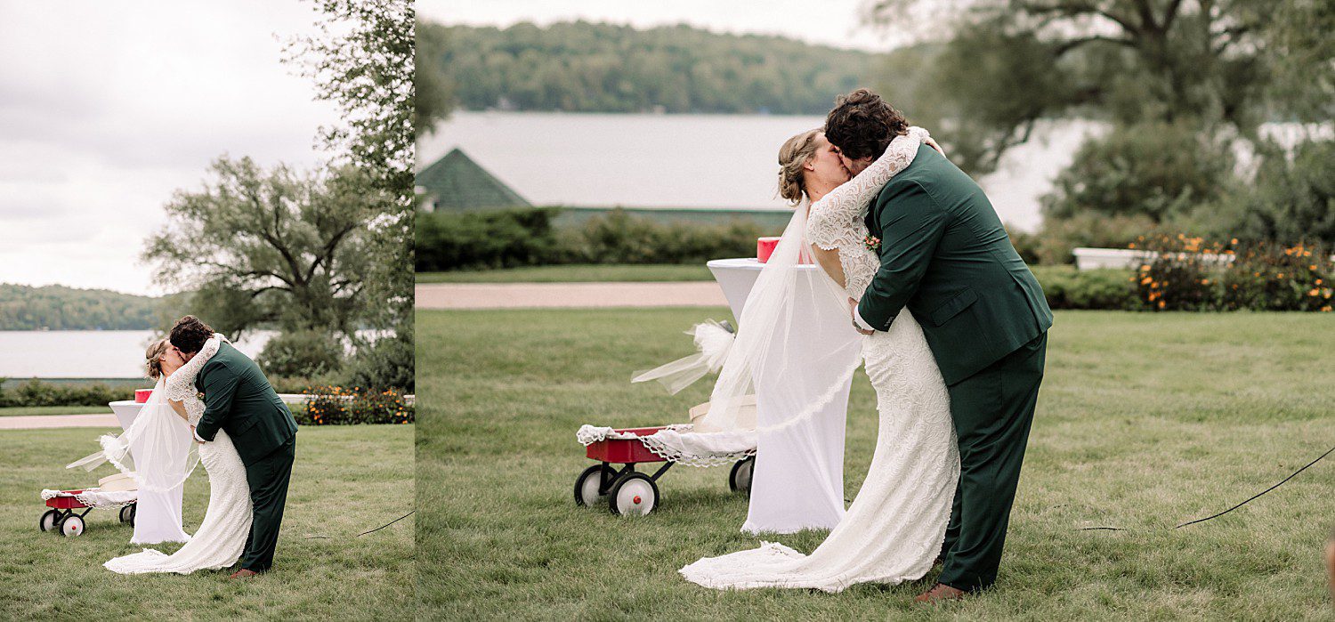 Logan dipping Kathryn for their first kiss at their lakeside ceremony at The Osthoff Resort in Elkhart Lake, Wisconsin