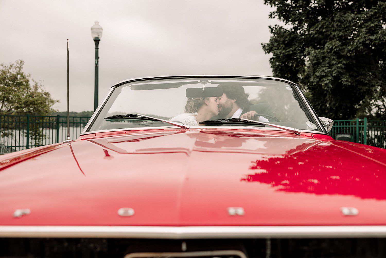 Kathryn and Logan kissing inside her dad's red 1967 Mustang convertible near Elkhart Lake, Wisconsin