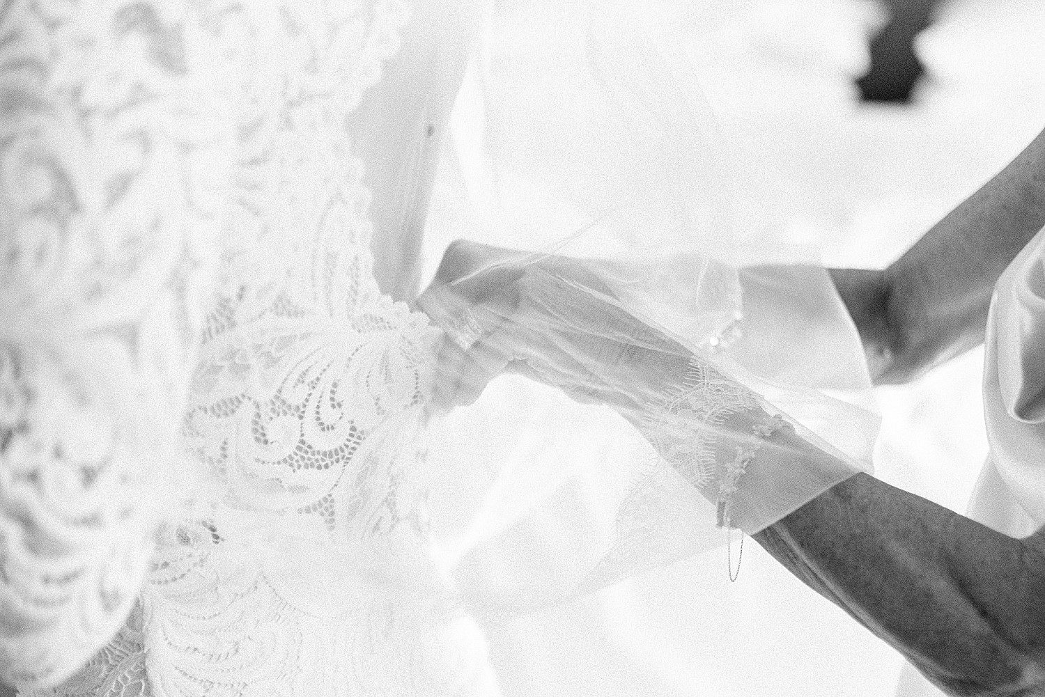 Black and white detail of Kathryn's lace sleeve and veil as she gets ready at The Osthoff Resort in Elkhart Lake, Wisconsin